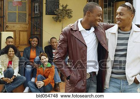 African men hugging with friends in background View Large Photo Image Stock Photo - African men hugging with friends in background. Fotosearch