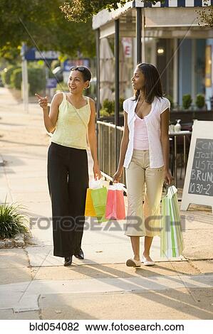 African mother and daughter carrying shopping bags View Large Photo Image Stock Image - African mother and daughter carrying shopping bags. Fotosearch