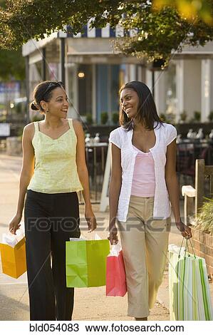 Stock Image - African mother and daughter carrying shopping bags. Fotosearch