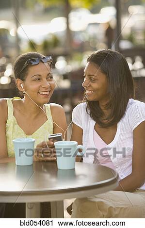 Stock Image - African mother and daughter listening to mp3 player. Fotosearch