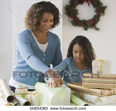 African mother and daughter wrapping gifts View Large Photo Image Stock Photography - African mother and daughter wrapping gifts. Fotosearch