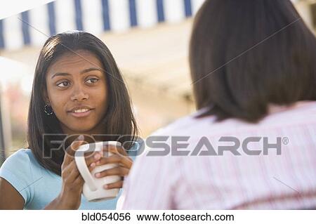 Stock Photograph - African teenaged girl talking to friend. Fotosearch