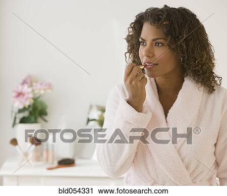 African woman applying lipstick View Large Photo Image Stock Image - African woman applying lipstick. Fotosearch