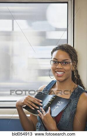 Stock Image - African woman holding bible. Fotosearch