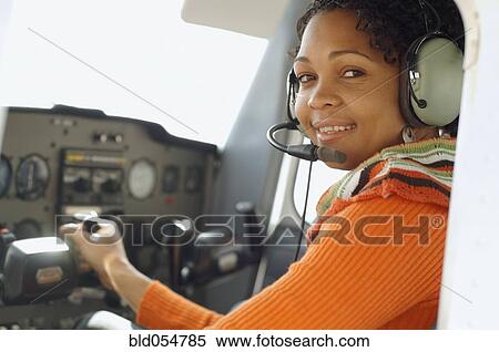 Stock Photography - African woman in cockpit of airplane. Fotosearch