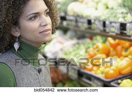 Stock Image - African woman in grocery store. Fotosearch