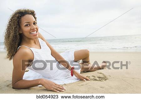 African woman laying on sand View Large Photo Image Stock Image - African woman laying on sand. Fotosearch
