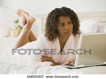 Stock Photo - African woman looking at laptop. Fotosearch