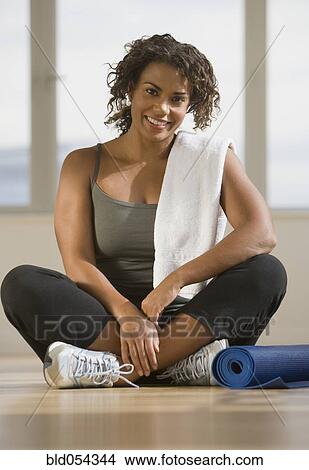 African woman sitting next to yoga mat View Large Photo Image Picture - African woman sitting next to yoga mat. Fotosearch