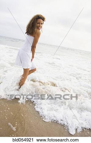 African woman standing in ocean surf View Large Photo Image Stock Image - African woman standing in ocean surf. Fotosearch