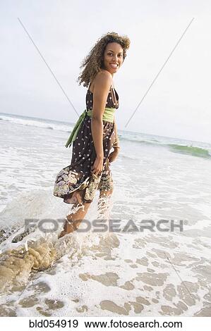 African woman wading in ocean surf View Large Photo Image Stock Photo - African woman wading in ocean surf. Fotosearch