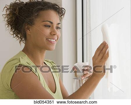Stock Image - African woman washing window. Fotosearch