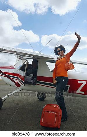 African woman with suitcase next to airplane View Large Photo Image Stock Image - African woman with suitcase next to airplane. Fotosearch