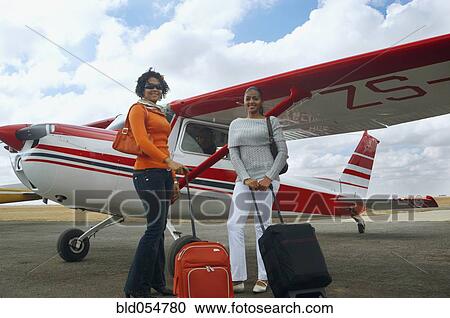 African woman with suitcases next to airplane View Large Photo Image Stock Image - African woman with suitcases next to airplane. Fotosearch