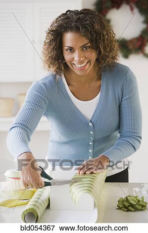 African woman wrapping gift View Large Photo Image Stock Photo - African woman wrapping gift. Fotosearch