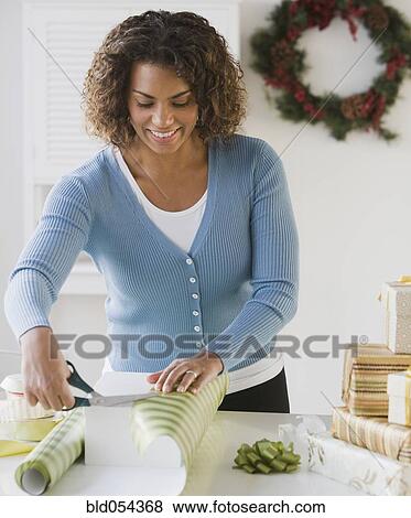 African woman wrapping gift View Large Photo Image Stock Photo - African woman wrapping gift. Fotosearch