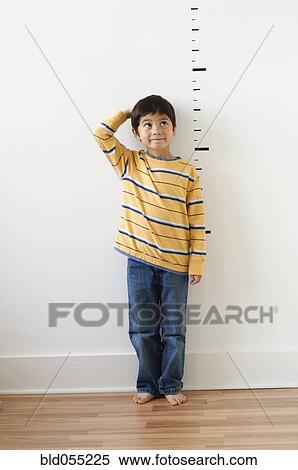 Asian boy standing next to height markers on wall View Large Photo Image Stock Photography - Asian boy standing next to height markers on wall. Fotosearch