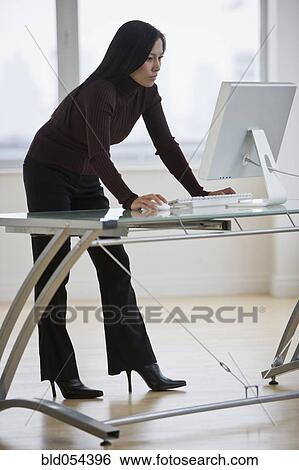 Stock Photograph - Asian businesswoman looking at computer. Fotosearch
