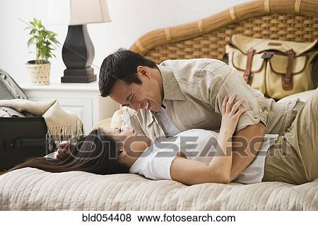 Asian couple hugging on bed View Large Photo Image Stock Photo - Asian couple hugging on bed. Fotosearch