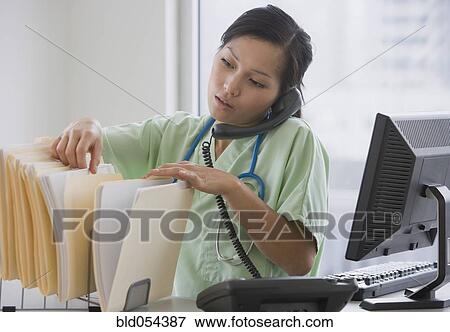 Asian female doctor talking on telephone View Large Photo Image Stock Photo - Asian female doctor talking on telephone. Fotosearch