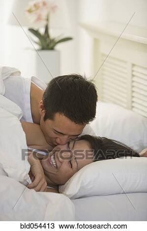 Asian man kissing wife on cheek View Large Photo Image Stock Image - Asian man kissing wife on cheek. Fotosearch
