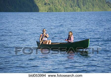 Picture - Asian mother and daughter rowing in canoe. Fotosearch