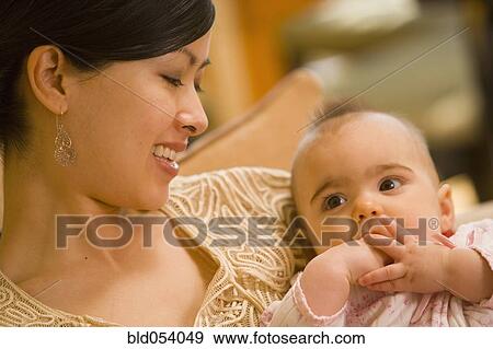 Stock Photo - Asian mother smiling at baby. Fotosearch