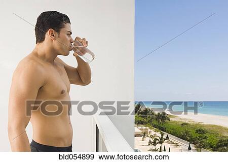 Bare-chested Hispanic man drinking water View Large Photo Image Stock Photo - Bare-chested Hispanic man drinking water. Fotosearch