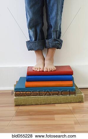 Boy standing on stack of books View Large Photo Image Stock Photo - Boy standing on stack of books. Fotosearch
