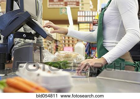 Stock Image - Cashier ringing up groceries. Fotosearch