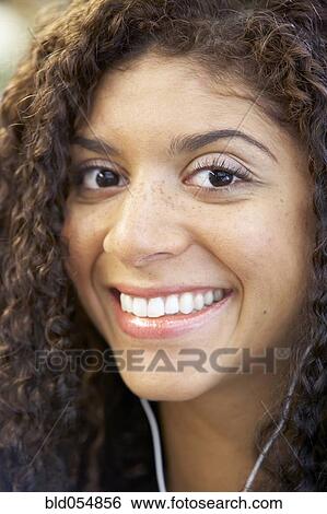 Stock Photograph - Close up of Mixed Race woman wearing headphones. Fotosearch