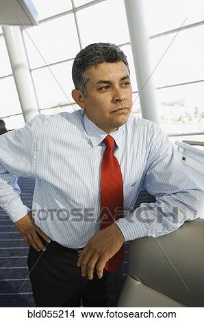 Hispanic businessman leaning on table View Large Photo Image Picture - Hispanic businessman leaning on table. Fotosearch