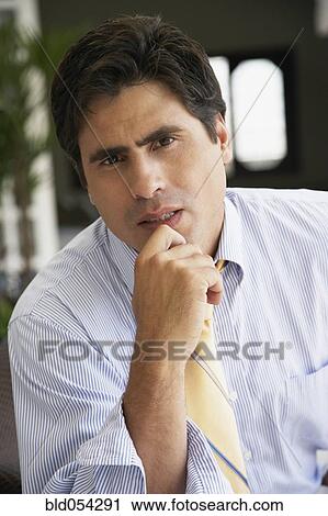 Hispanic businessman resting chin in hand View Large Photo Image Stock Image - Hispanic businessman resting chin in hand. Fotosearch