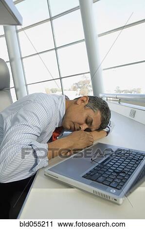 Hispanic businessman sleeping next to laptop View Large Photo Image Stock Image - Hispanic businessman sleeping next to laptop. Fotosearch
