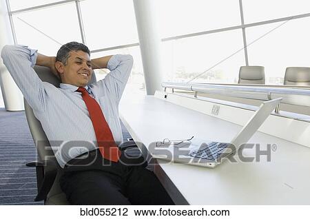 Hispanic businessman with hands behind head View Large Photo Image Stock Image - Hispanic businessman with hands behind head. Fotosearch