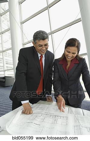 Hispanic businesspeople looking at blueprints View Large Photo Image Stock Photo - Hispanic businesspeople looking at blueprints. Fotosearch