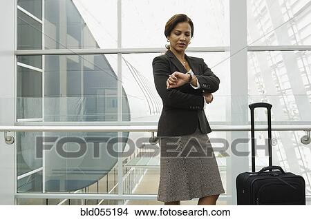 Hispanic businesswoman checking watch View Large Photo Image Picture - Hispanic businesswoman checking watch. Fotosearch