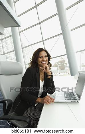 Hispanic businesswoman next to laptop View Large Photo Image Stock Image - Hispanic businesswoman next to laptop. Fotosearch