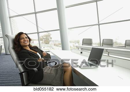 Stock Image - Hispanic businesswoman next to laptop. Fotosearch
