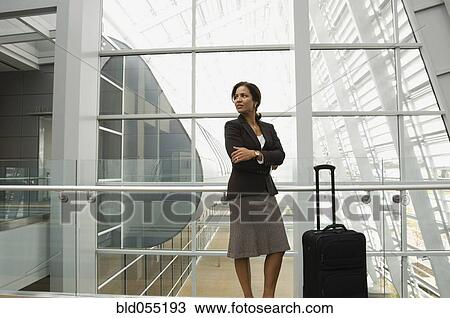 Hispanic businesswoman standing next to suitcase View Large Photo Image Stock Image - Hispanic businesswoman standing next to suitcase. Fotosearch