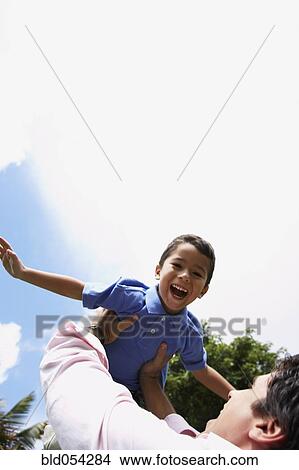 Hispanic father holding son in air View Large Photo Image Picture - Hispanic father holding son in air. Fotosearch