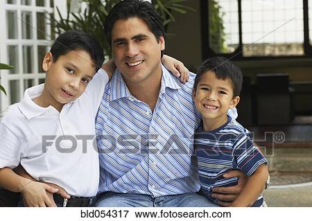 Stock Photo - Hispanic father hugging sons. Fotosearch
