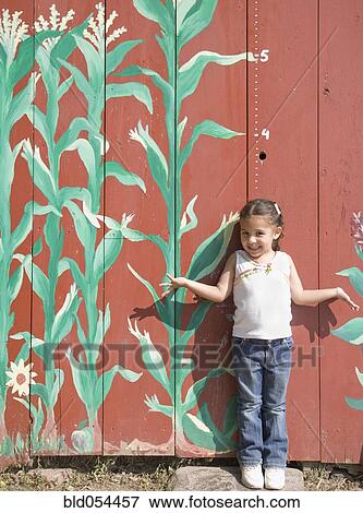 Stock Photo - Hispanic girl in front of height marker. Fotosearch