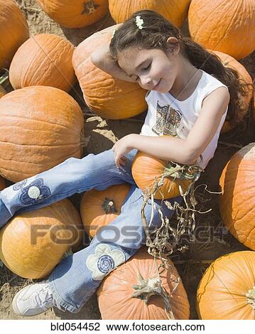 Hispanic girl laying in pumpkin patch View Large Photo Image Stock Image - Hispanic girl laying in pumpkin patch. Fotosearch