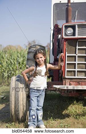 Hispanic girl next to tractor View Large Photo Image Stock Photo - Hispanic girl next to tractor. Fotosearch