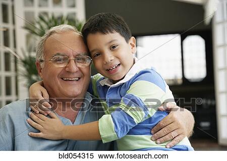 Stock Photography - Hispanic grandfather and grandson hugging. Fotosearch