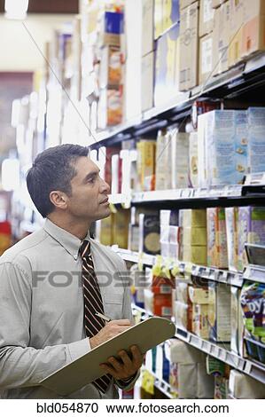 Hispanic grocery store manager writing on clipboard View Large Photo Image Stock Image - Hispanic grocery store manager writing on clipboard. Fotosearch