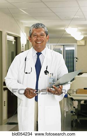 Hispanic male doctor holding chart View Large Photo Image Picture - Hispanic male doctor holding chart. Fotosearch