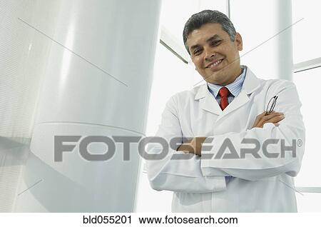 Hispanic male doctor with arms crossed View Large Photo Image Stock Image - Hispanic male doctor with arms crossed. Fotosearch