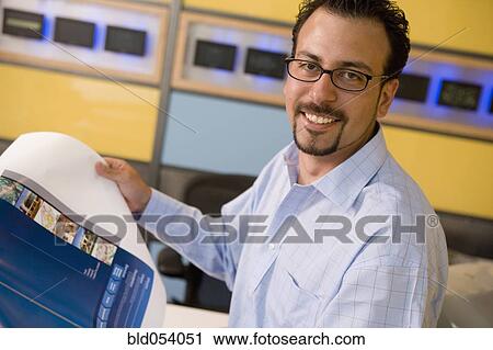 Hispanic male graphic designer holding printout View Large Photo Image Stock Image - Hispanic male graphic designer holding printout. Fotosearch